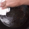 Pulizia di una padella di ghisa bruciata