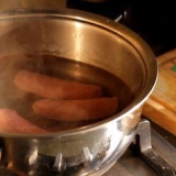 Grigliare la salsiccia sul barbecue