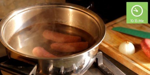 Grigliare la salsiccia sul barbecue